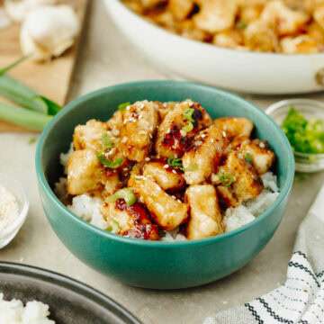 Easy Orange Chicken served over white rice in a blue bowl.