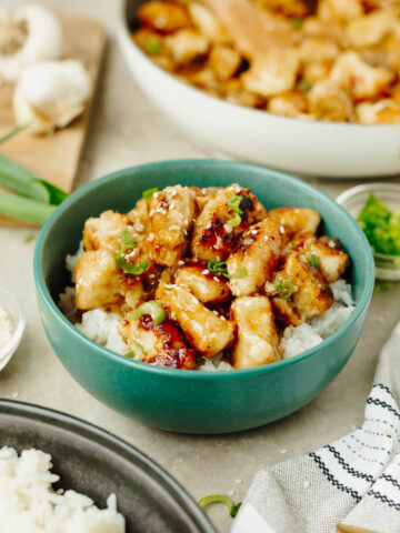 Easy Orange Chicken served over white rice in a blue bowl.