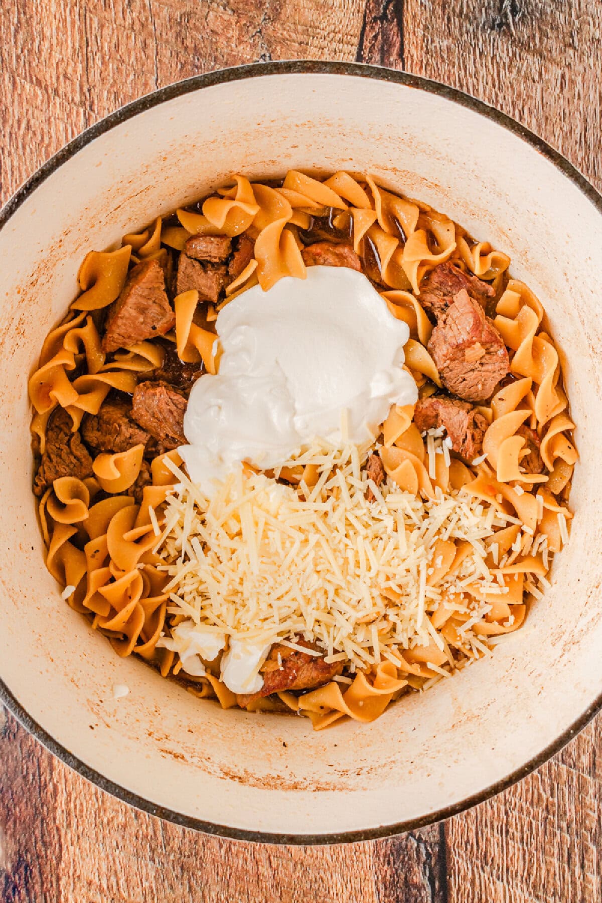 Sour cream and Parmesan cheese added to a Dutch oven.