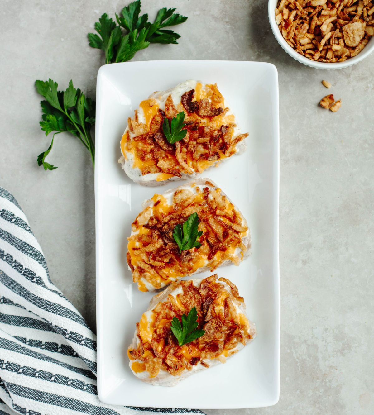 Juicy French onion pork chops served on a white platter.