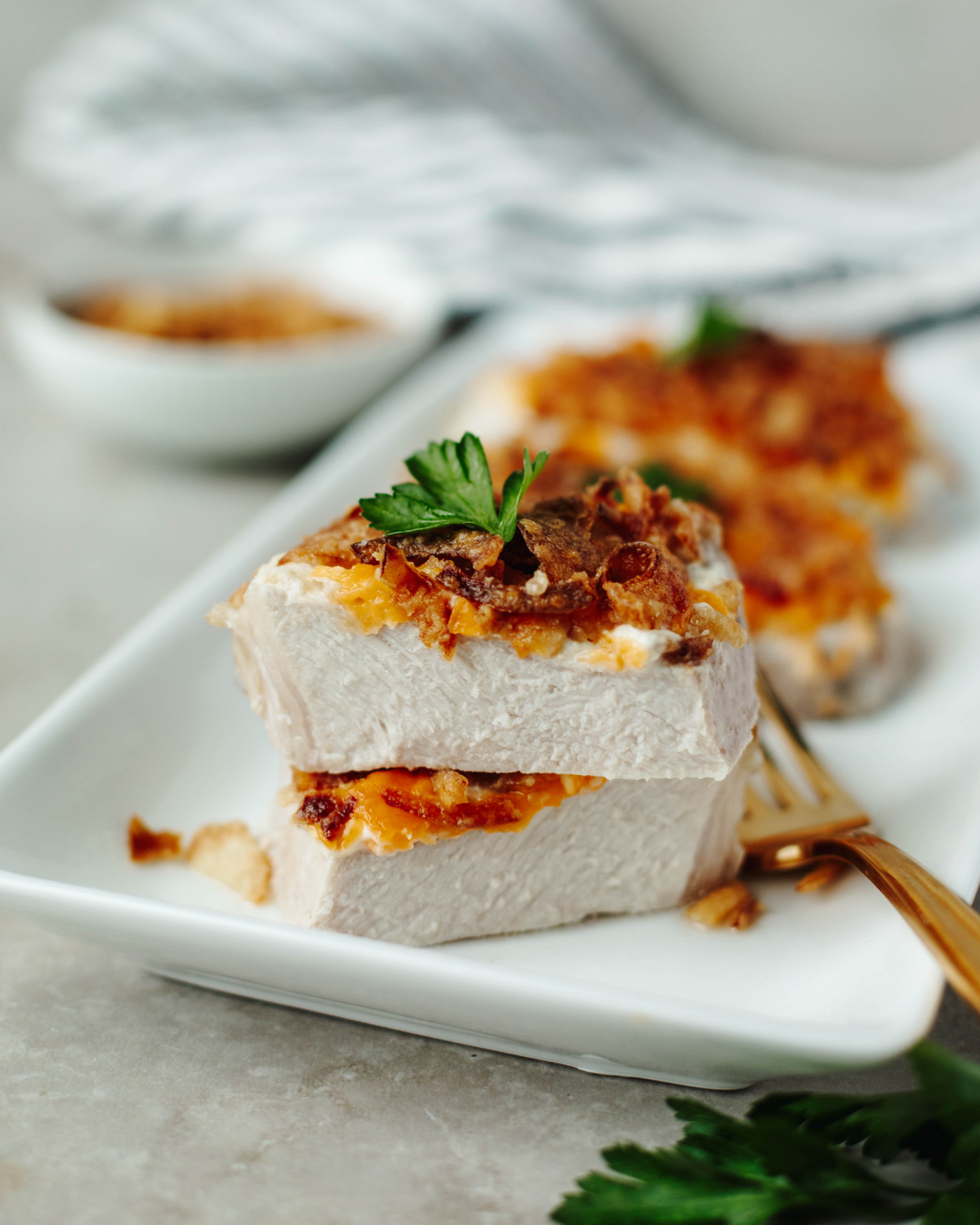 French Onion Pork Chops served on a white plate and sliced in half to show the cooked center.