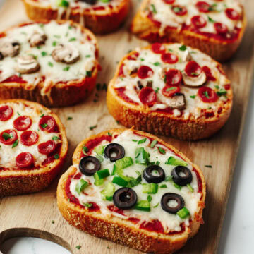 Baked garlic toast with pizza sauce, cheese, and toppings.