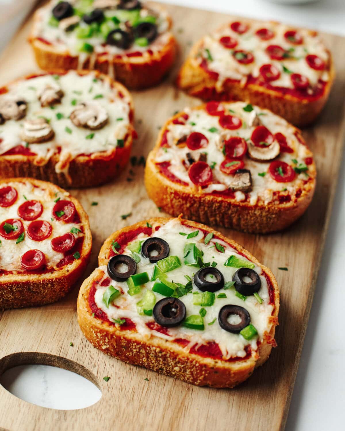 Baked garlic toast with pizza sauce, cheese, and toppings.