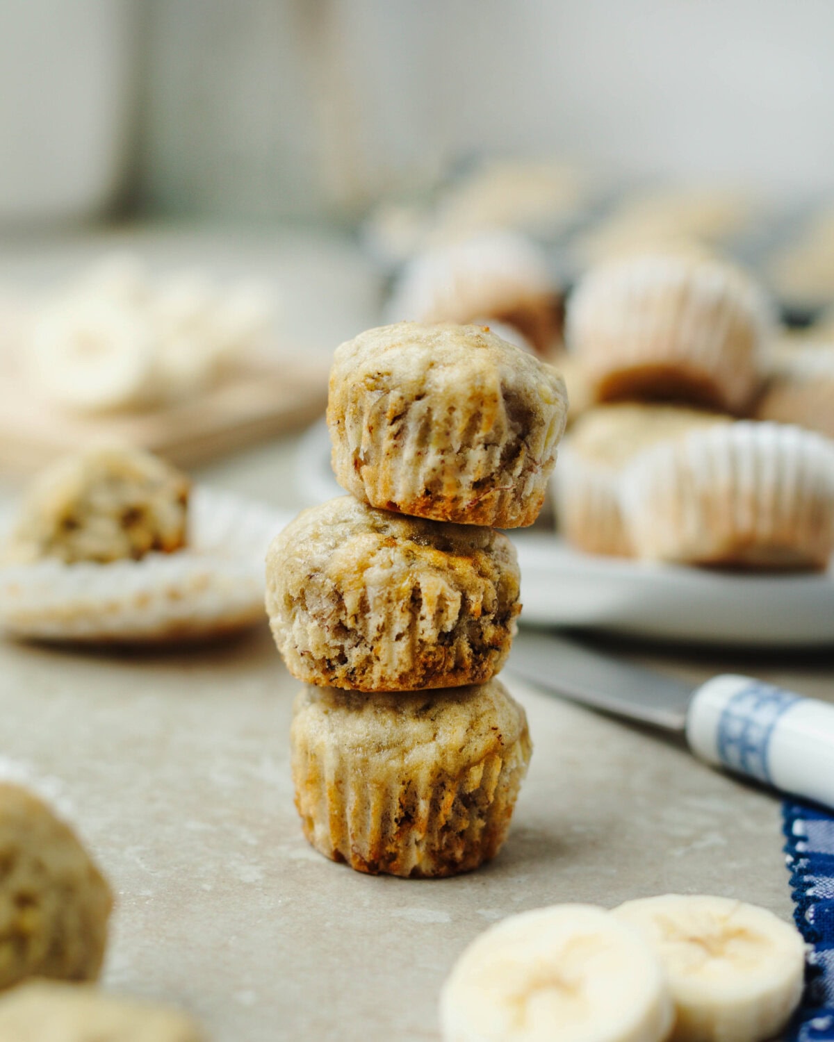 A stack of three mini banana muffins on a serving tray.