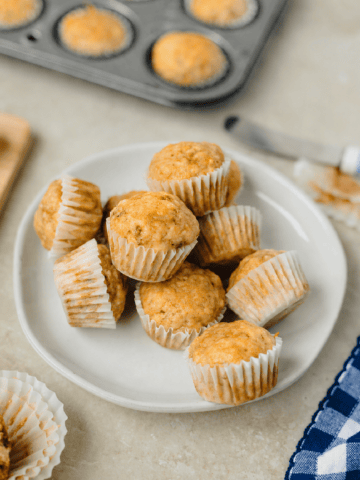 A white plate with mini banana muffins ready to serve.