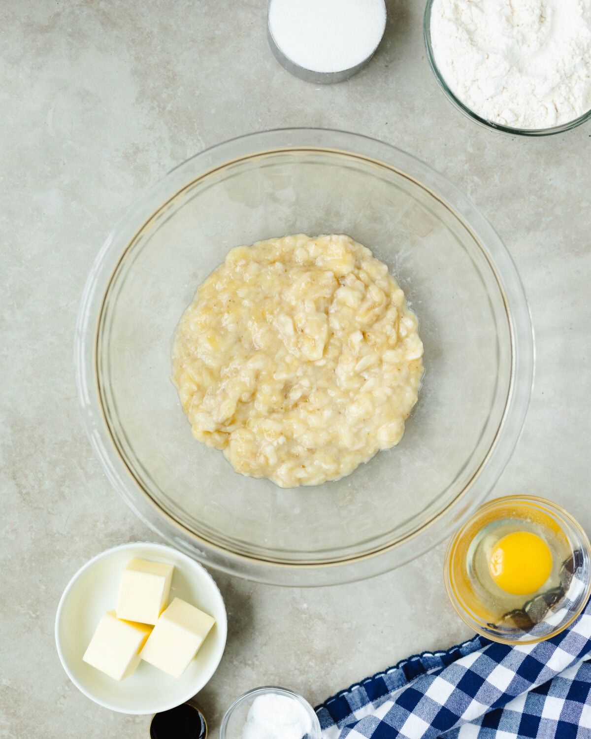 Mashed bananas in a glass mixing bowl.