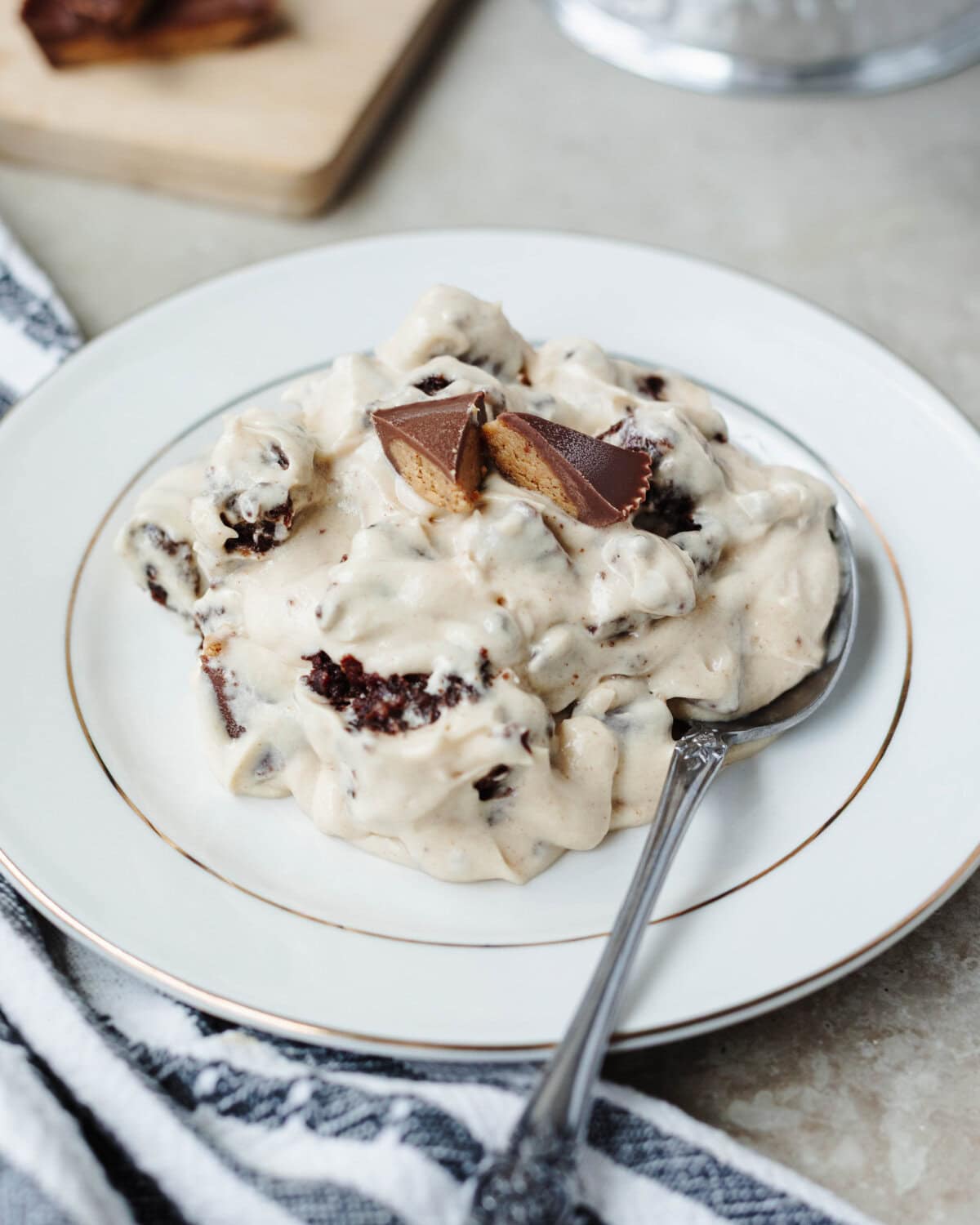 A serving of peanut butter brownie trifle on a white dessert plate.