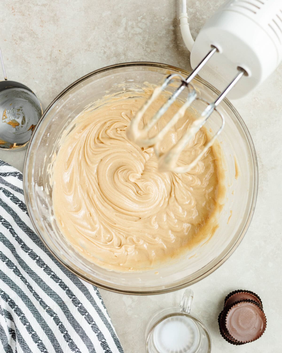 Cream cheese and powdered sugar combined until smooth and creamy using an electric mixer in a glass bowl.