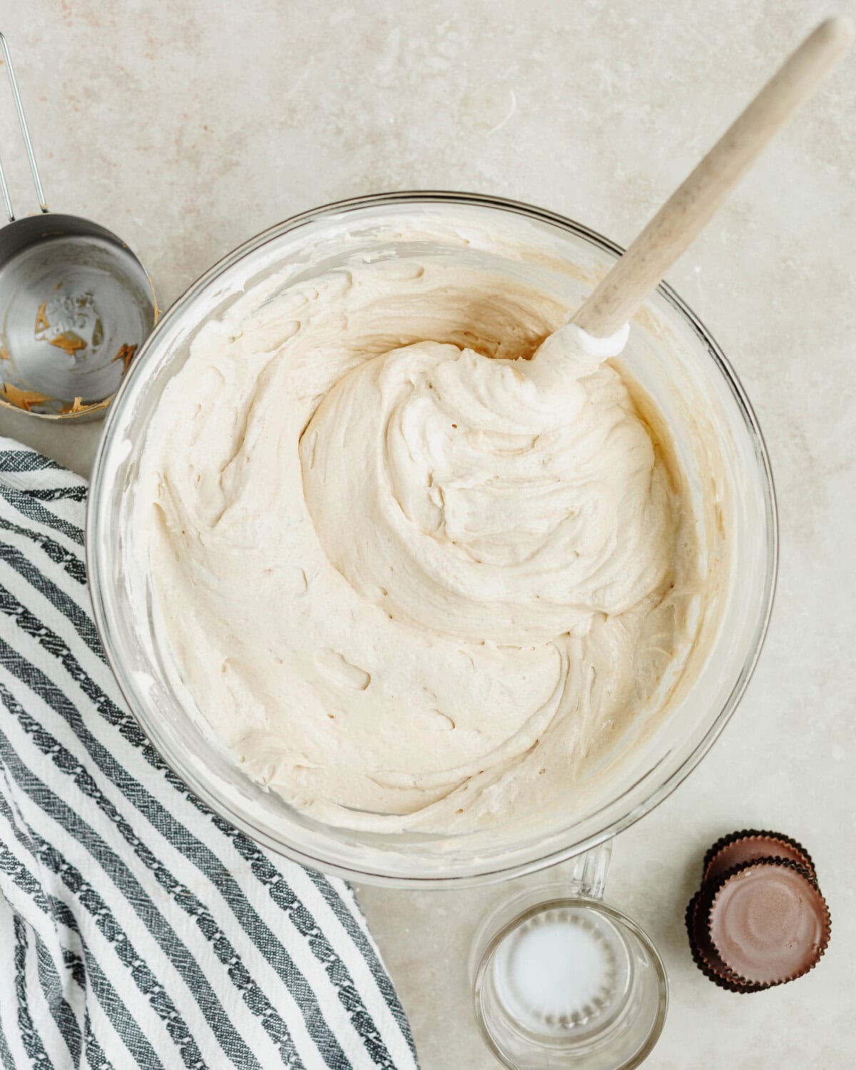 Peanut butter, milk, cool whip, cream cheese, and powdered sugar combined in a glass bowl.