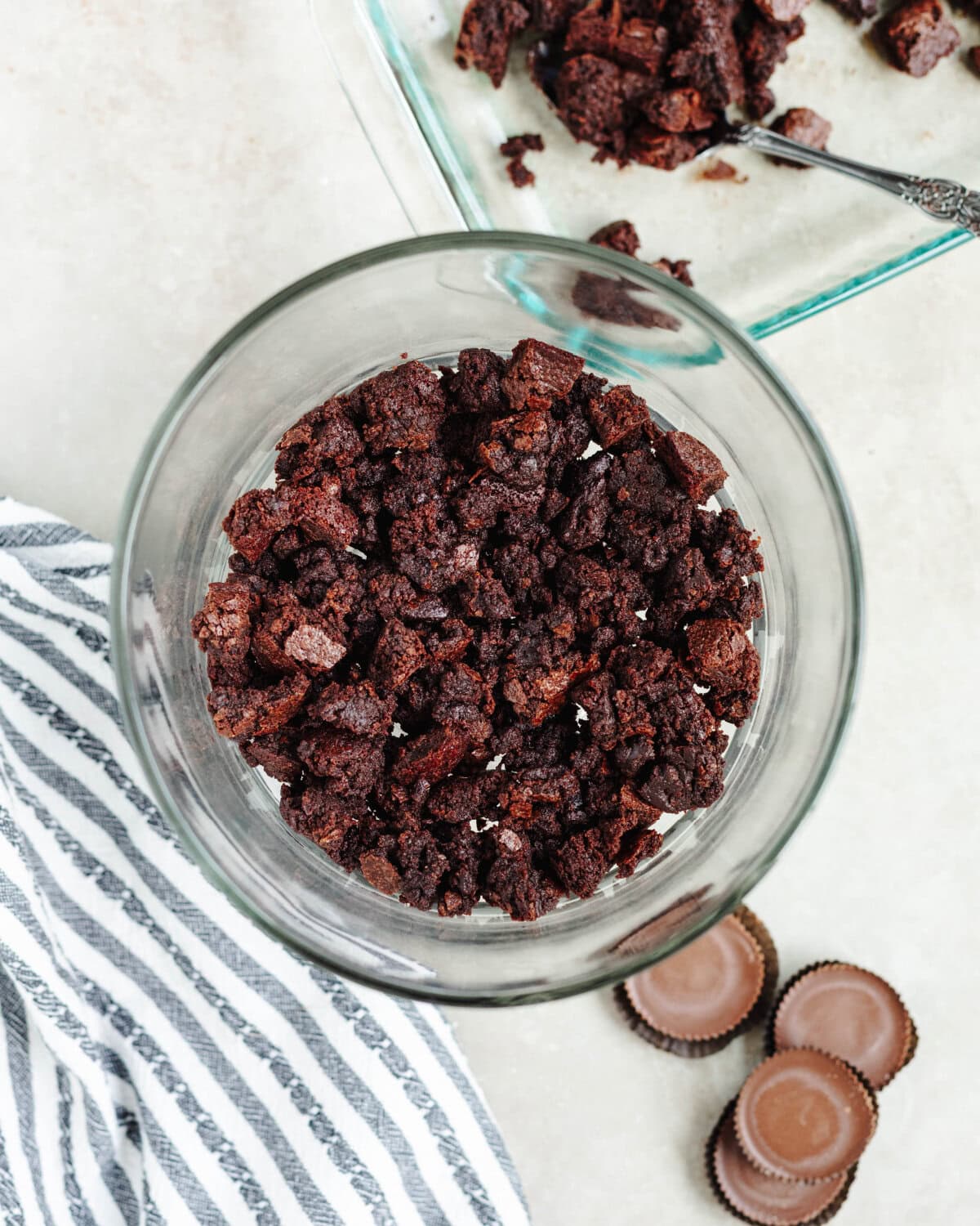 Chopped brownie pieces arranged in a single layer in a glass bowl.