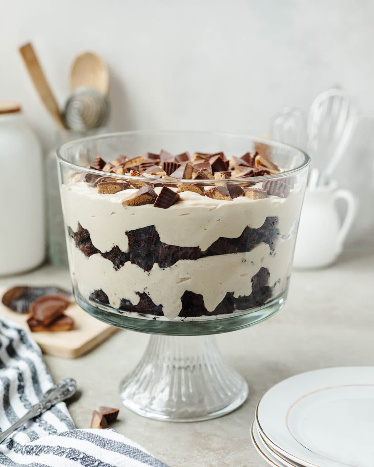 A side view of a peanut butter brownie trifle ready to serve from a glass trifle bowl.
