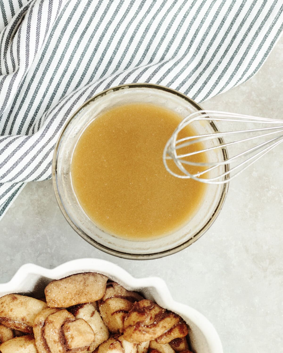 Melted butter, sugar, and pumpkin pie spice whisked together in a glass bowl.