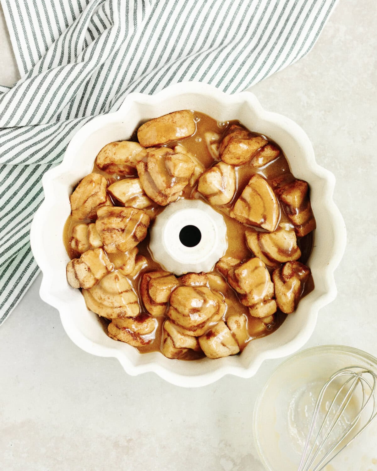 Cinnamon roll pieces added to a bundt pan with a pumpkin spice mixture poured on top.