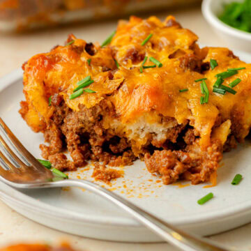 An up close look at a piece of sloppy joe biscuit casserole served on a white plate.