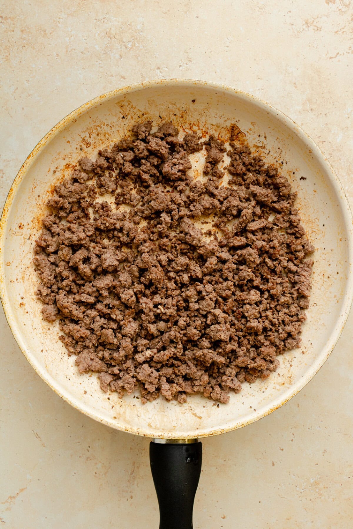 Ground beef cooking in a skillet until browned.