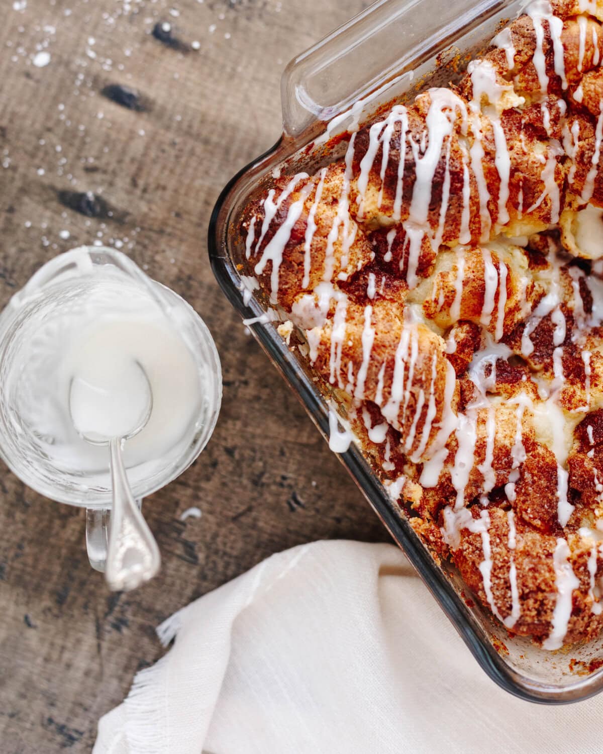 Powdered sugar and milk combined in a bowl and drizzled on top of baked apple cinnamon biscuits.