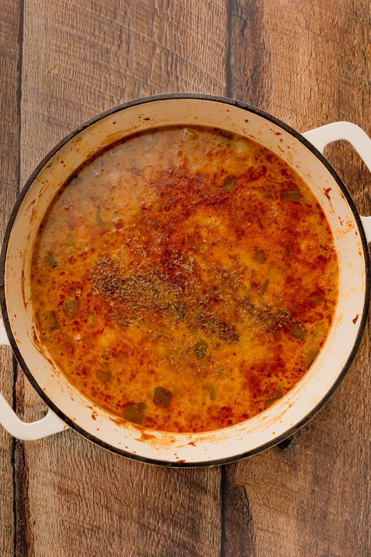 Chicken, garlic, Worcestershire sauce, Cajun seasoning, and thyme added to roux in a Dutch oven.
