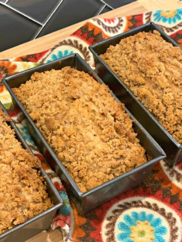Mini loaves of cinnamon crumble banana bread in loaf pans.