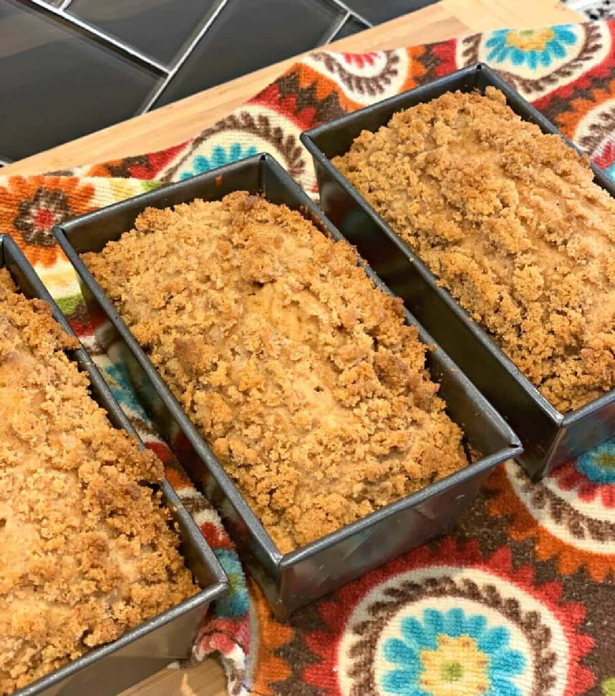 Mini loaves of cinnamon crumble banana bread in loaf pans.