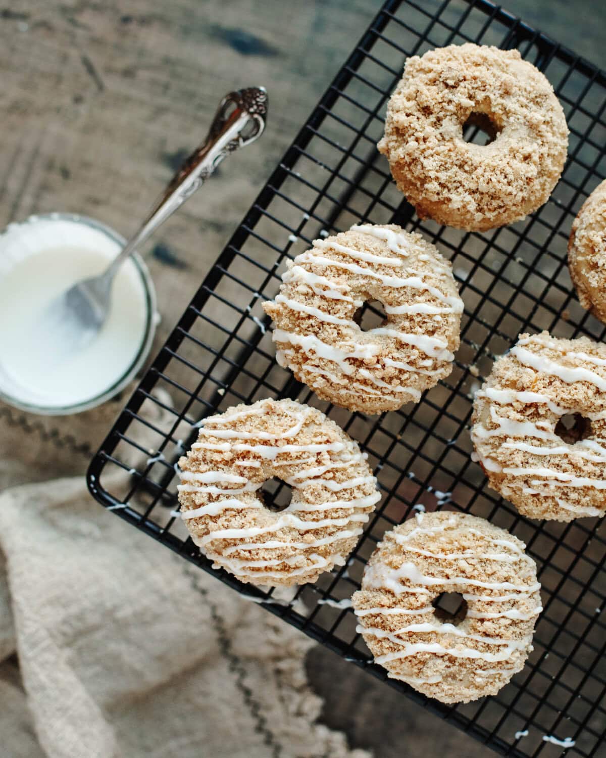 Powdered sugar glaze drizzled on top of baked donuts.
