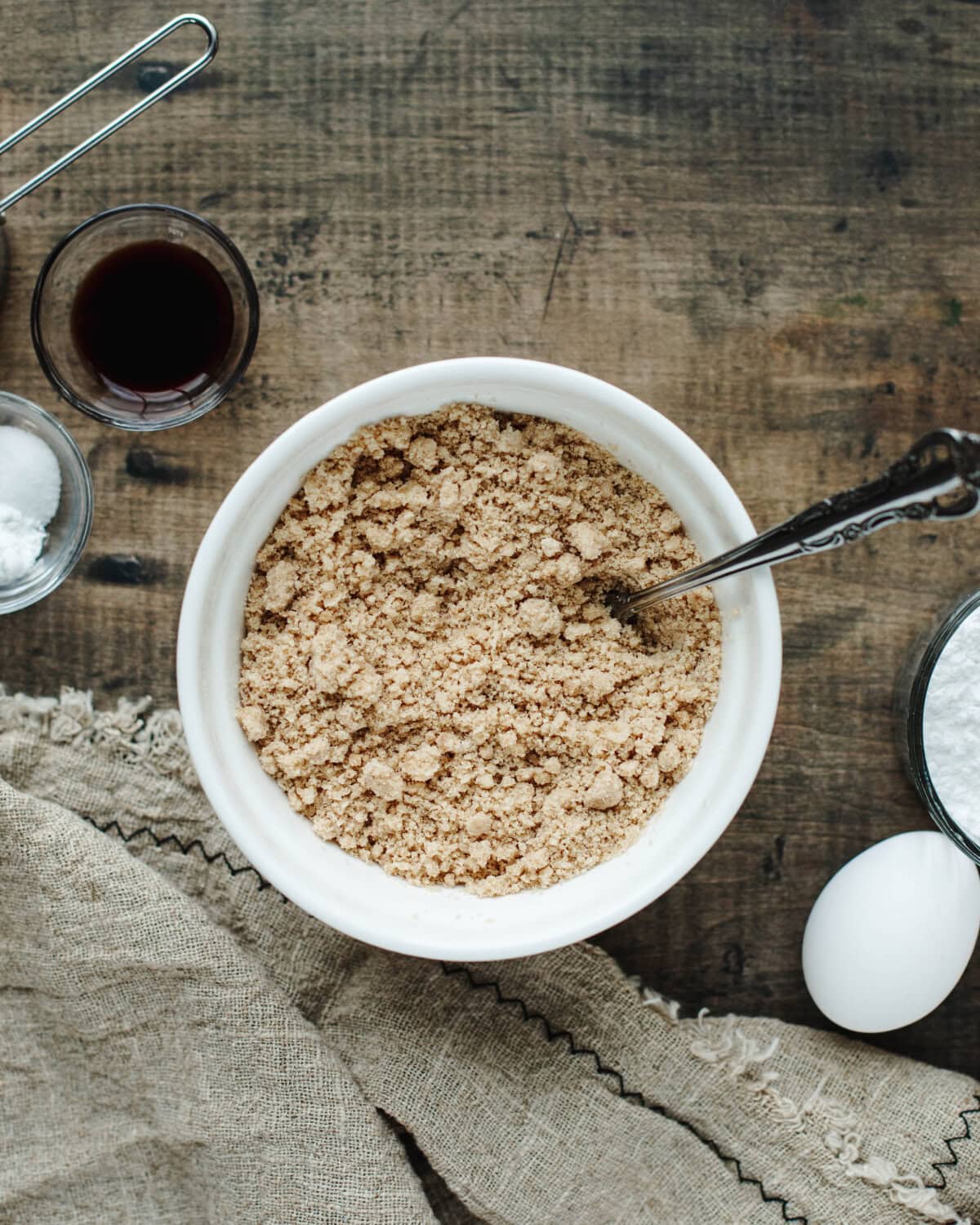 Melted butter, brown sugar, flour, and cinnamon combined in a white bowl until crumbs form.