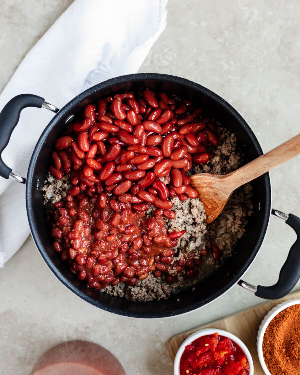 Red kidney beans and chili beans added to browned ground beef.