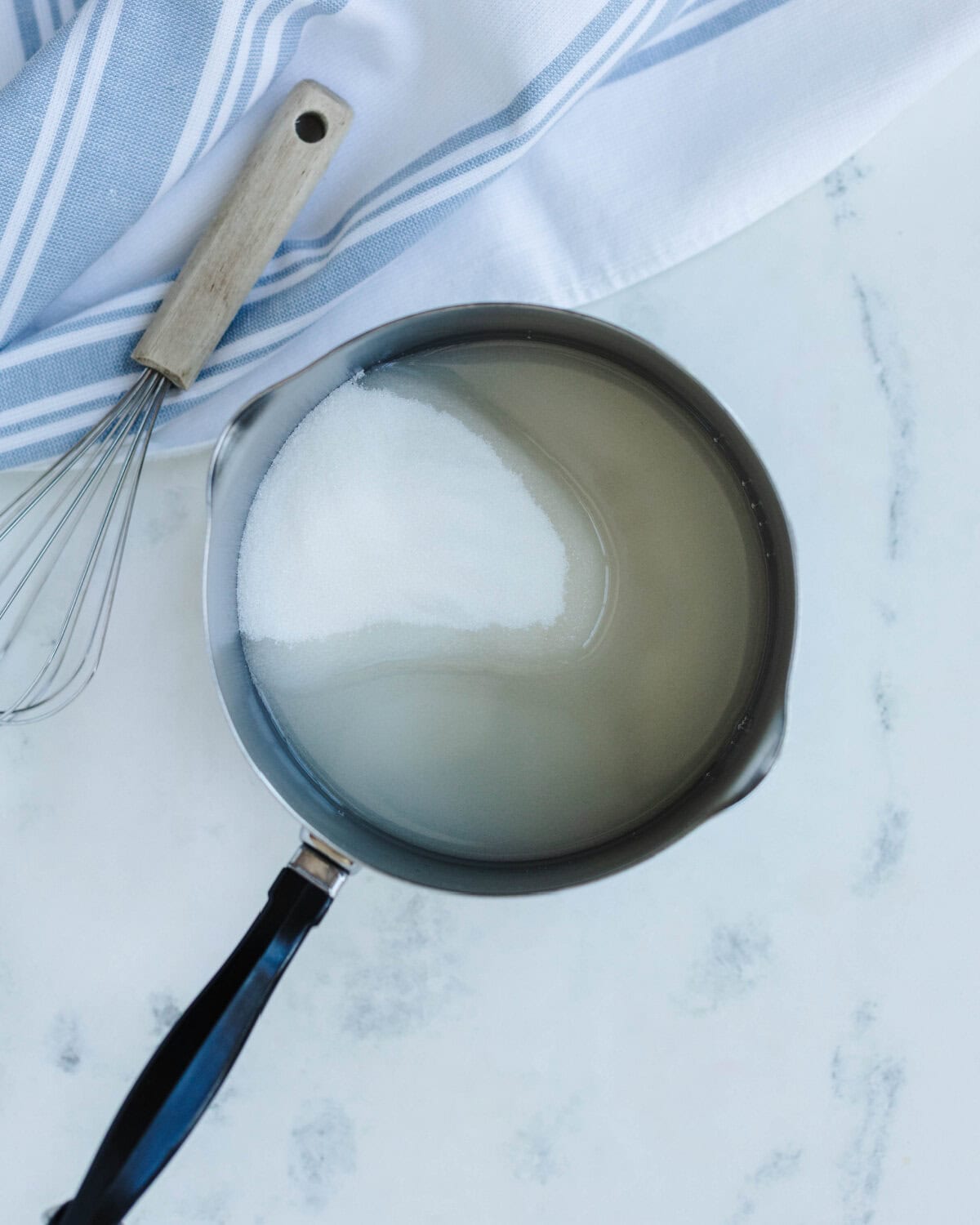 Sugar and water combined in a saucepan.