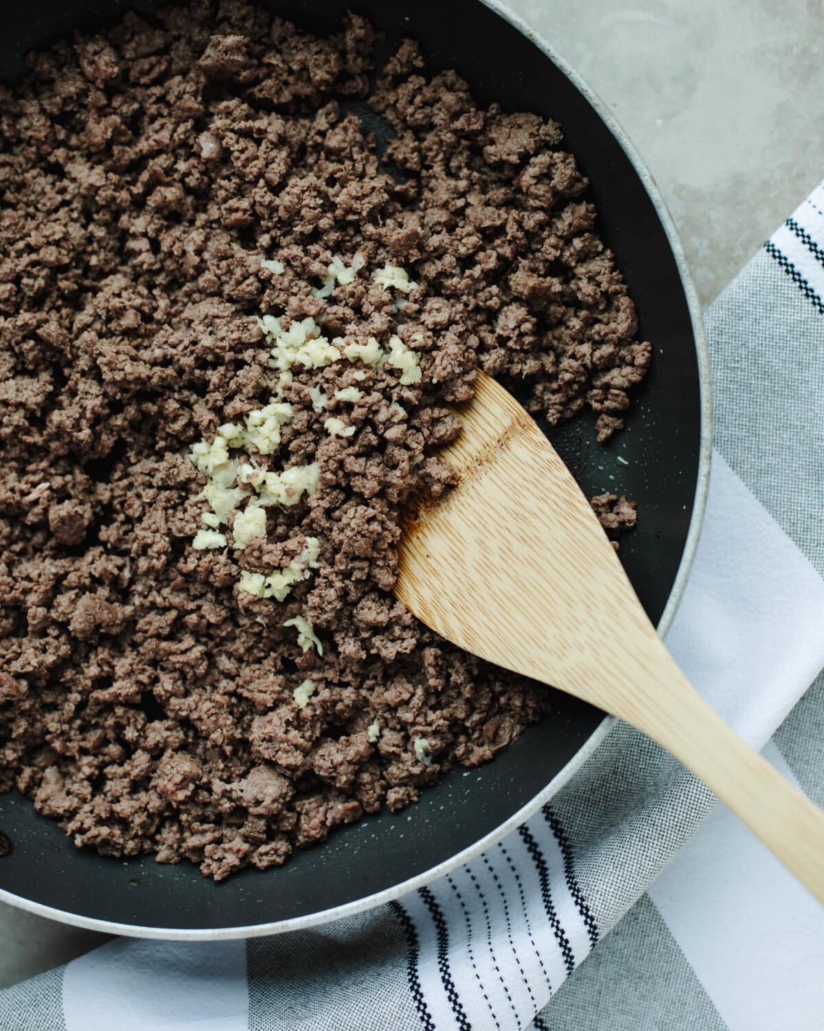 Ground beef cooked with garlic in a skillet until browned.