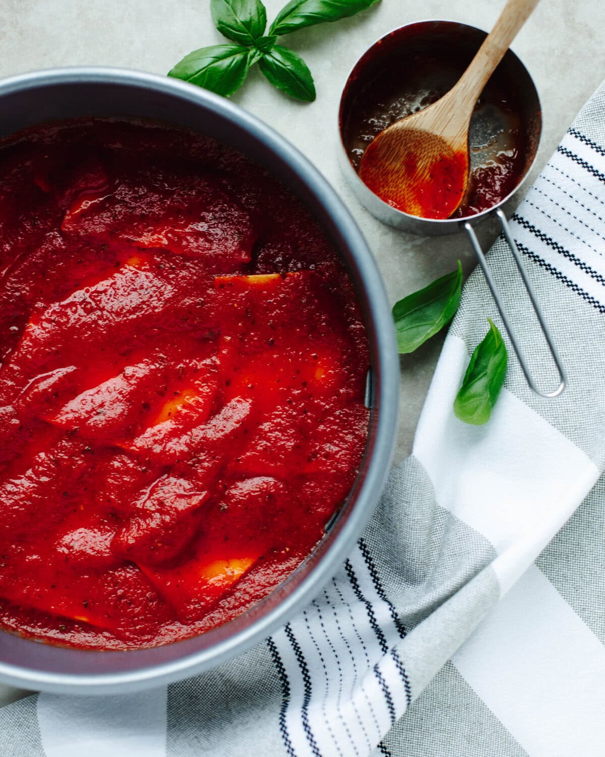 Spaghetti sauce spread to cover lasagna noodles on the bottom of a springform pan.