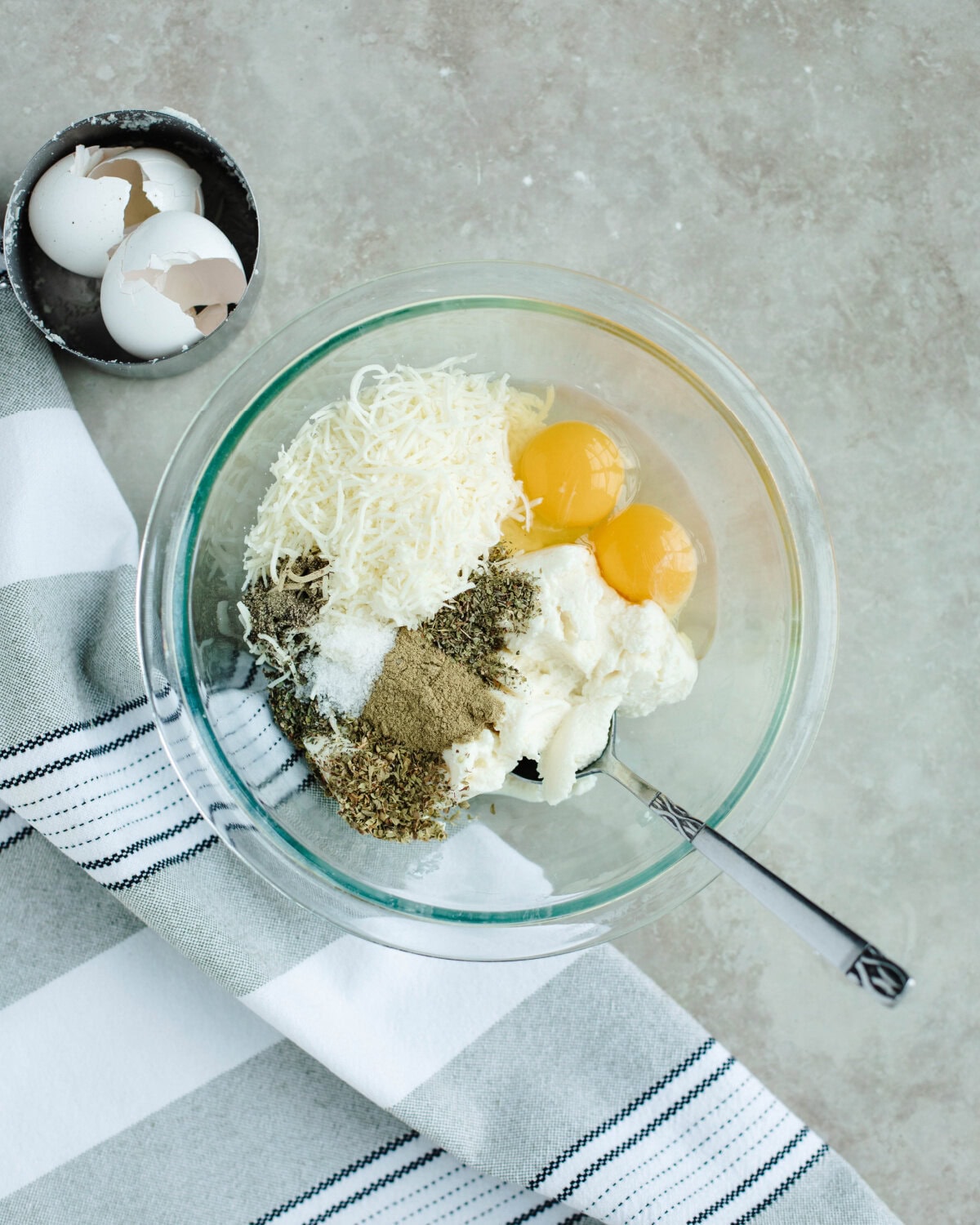 Ricotta cheese, mozzarella, seasonings, and egg combined in a bowl.