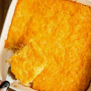 A baked jiffy cornbread casserole with a spatula removing a slice.