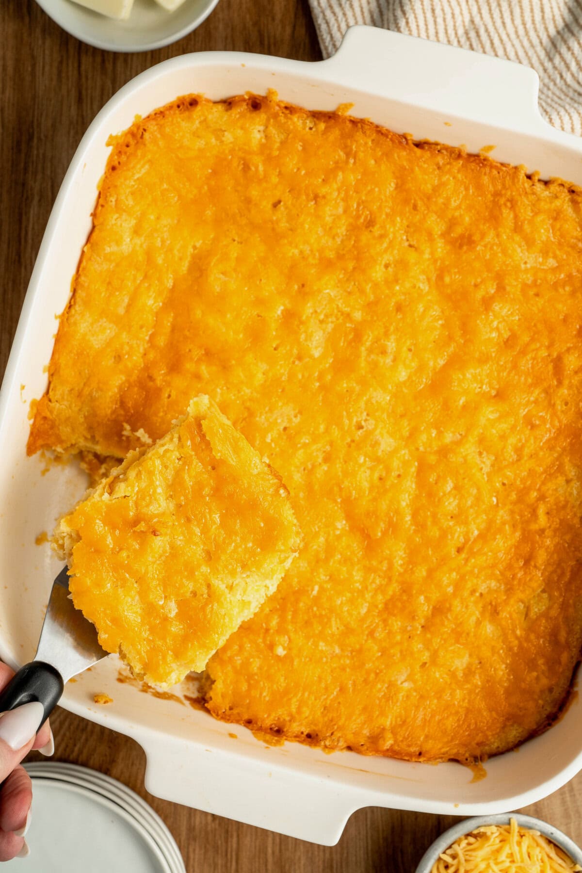 A baked jiffy cornbread casserole with a spatula removing a slice.