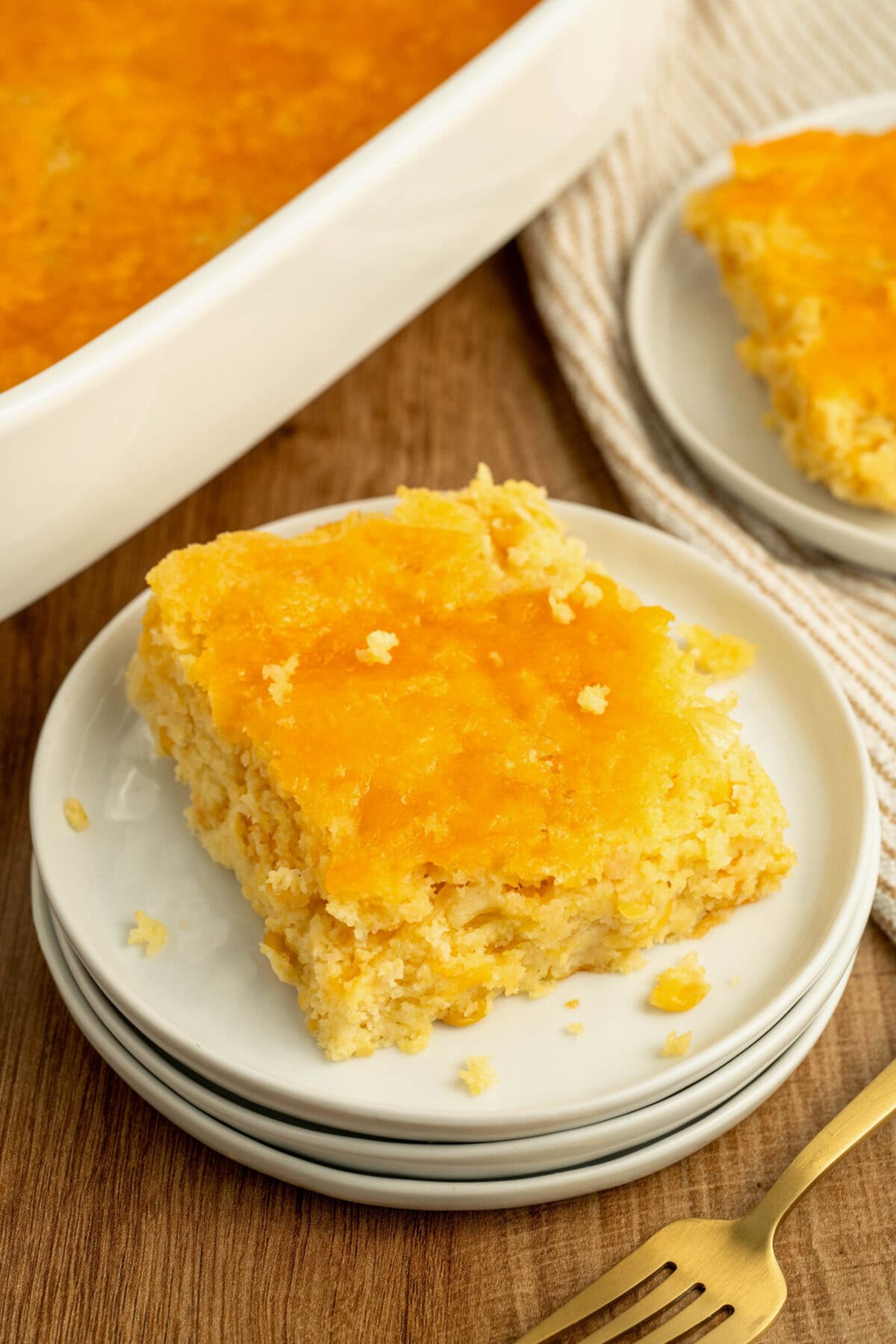 Jiffy cornbread casserole served on a white plate with a fork.