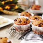An up close look at baked pumpkin banana chocolate chip muffins on a black wire rack.