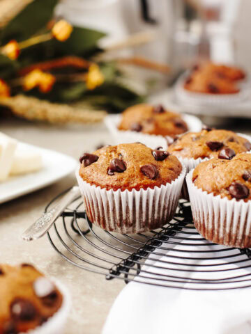 An up close look at baked pumpkin banana chocolate chip muffins on a black wire rack.