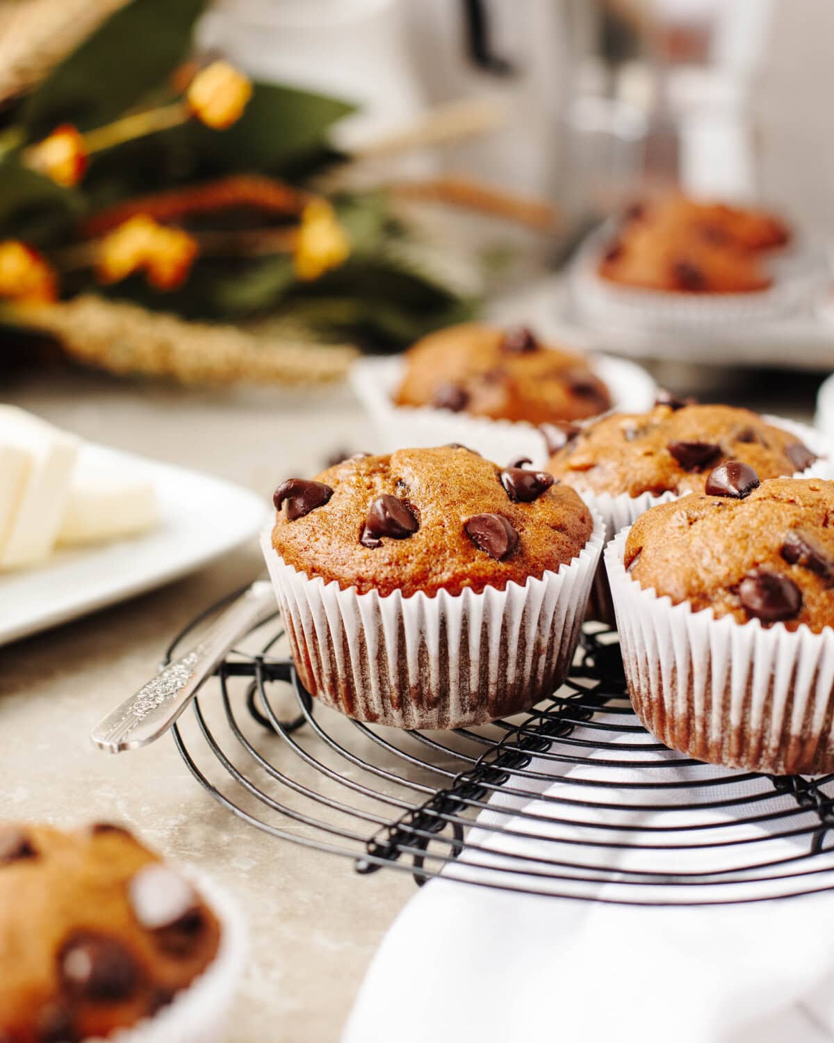 An up close look at baked pumpkin banana chocolate chip muffins on a black wire rack.