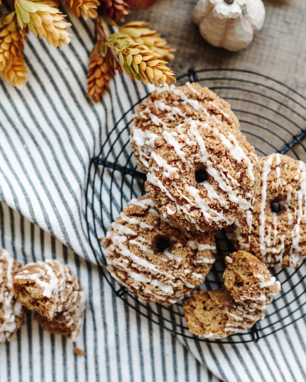Baked pumpkin spice donuts on a wire rack ready to serve.