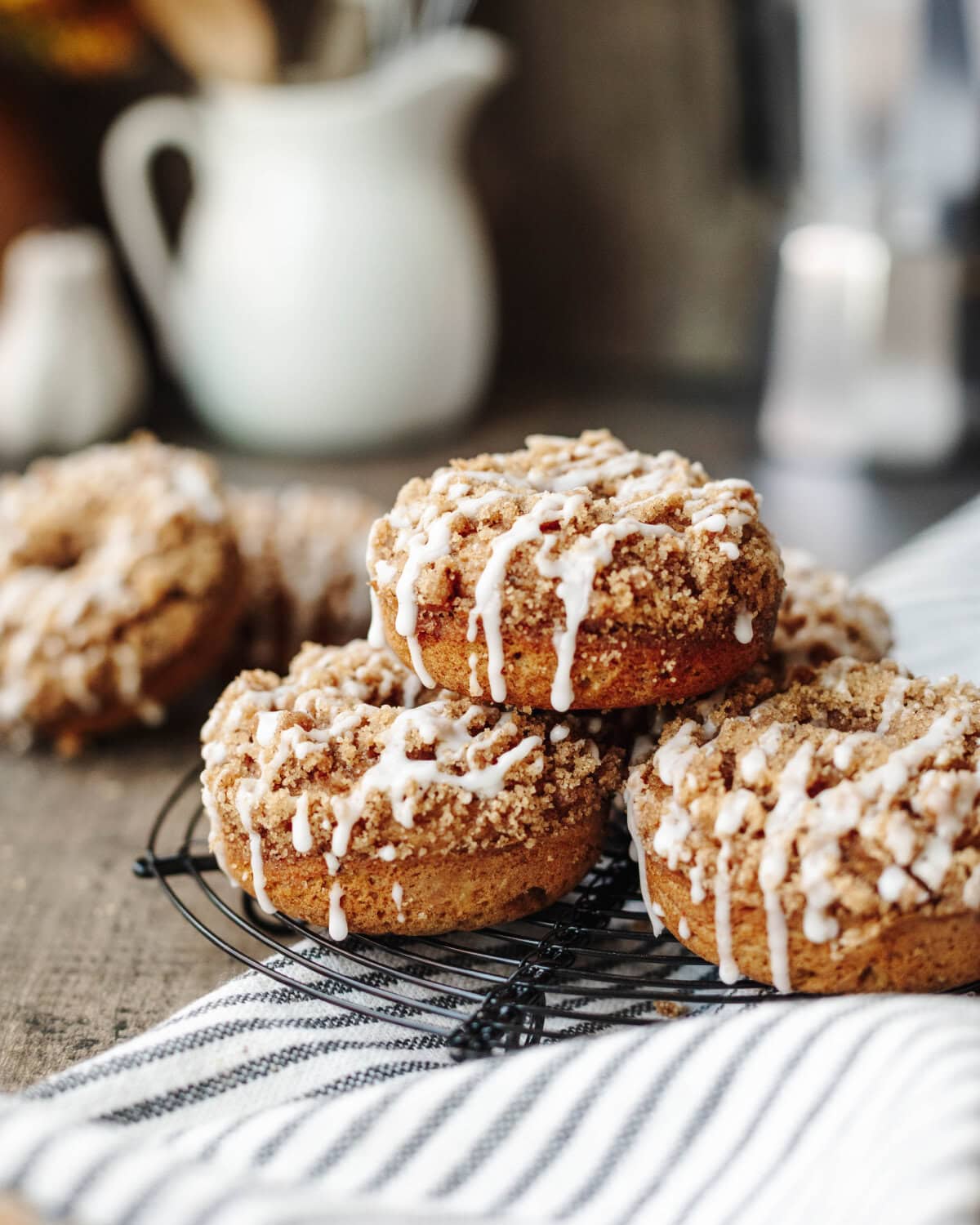 A stack of pumpkin coffee cake donuts on a wire rack.