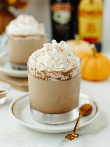 Pumpkin Spice Mudslide in a glass garnished with cinnamon and whipped cream.