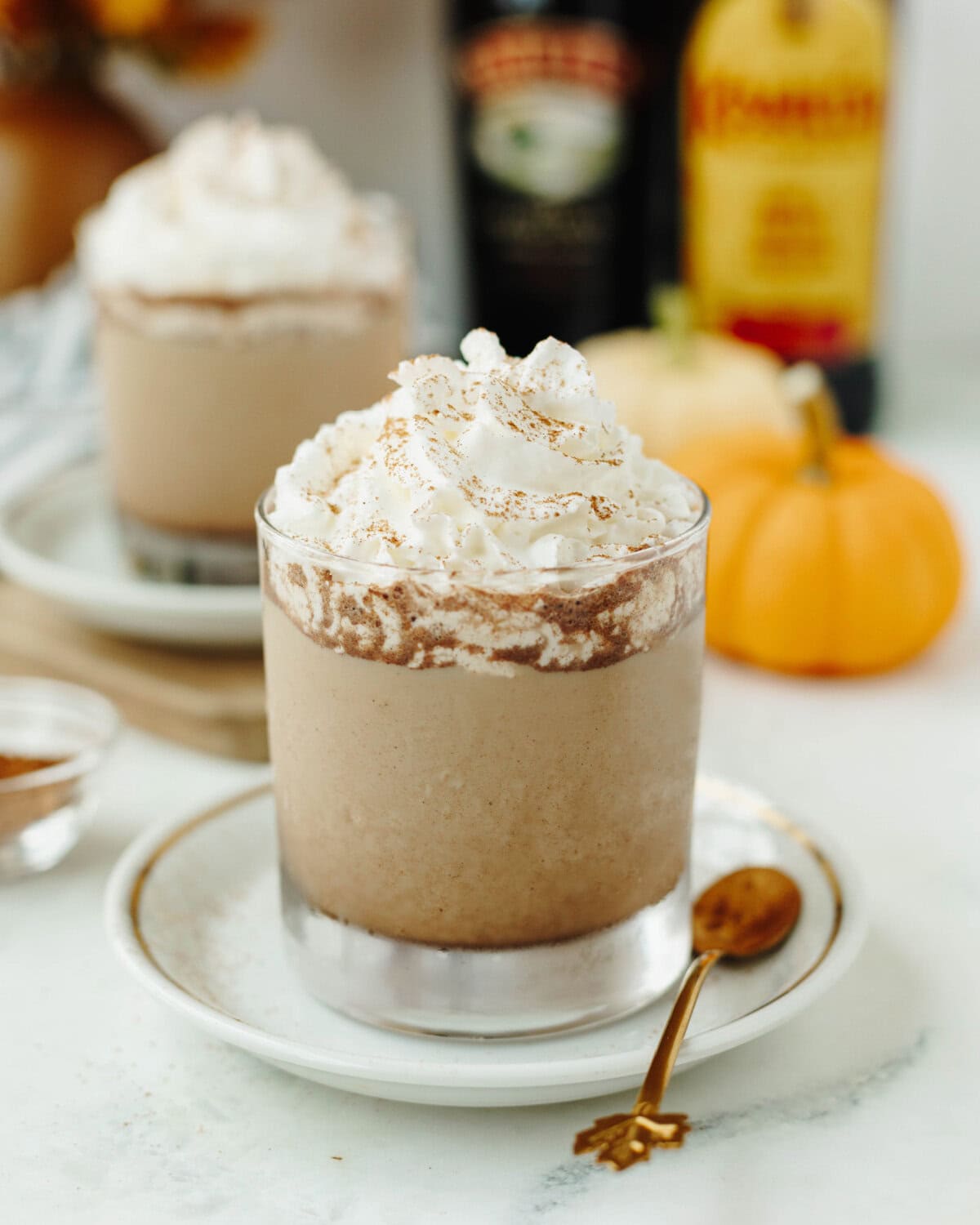 Pumpkin Spice Mudslide in a glass garnished with cinnamon and whipped cream.