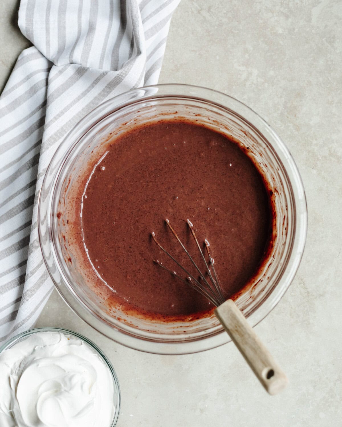 A chocolate boozy pudding mixture whisked together in glass mixing bowl.