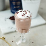 A glass dish filled with Rumchata pudding, whipped cream, and sprinkles ready to enjoy.