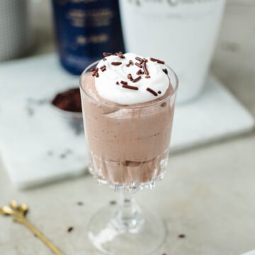 A glass dish filled with Rumchata pudding, whipped cream, and sprinkles ready to enjoy.