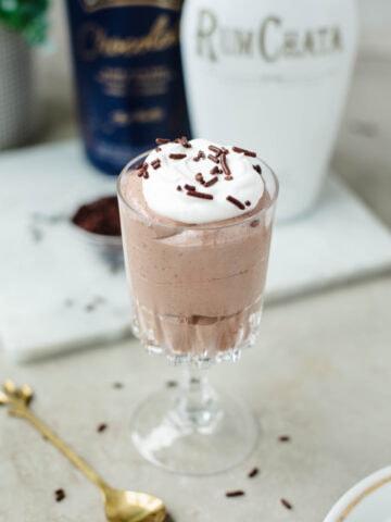 A glass dish filled with Rumchata pudding, whipped cream, and sprinkles ready to enjoy.