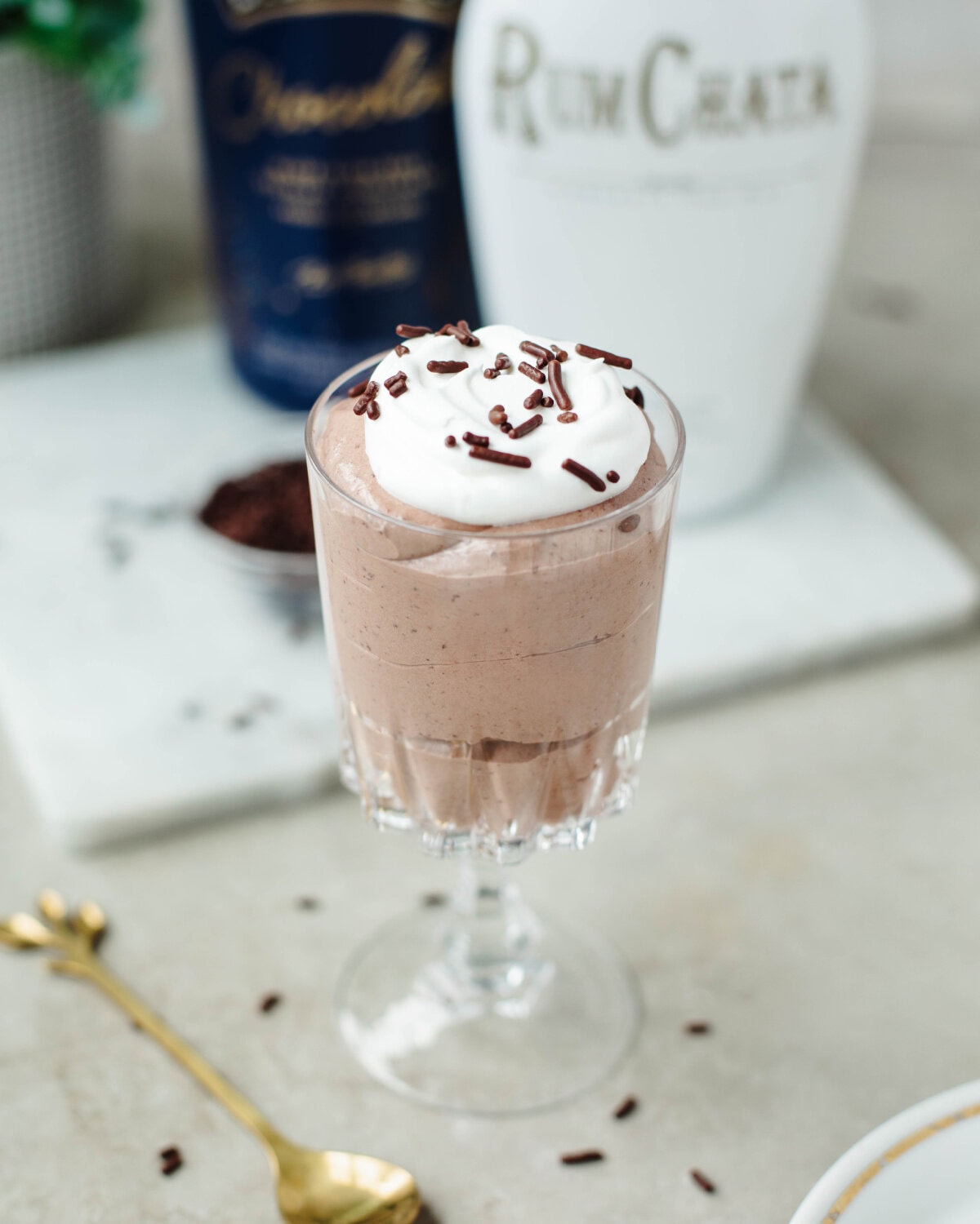 A glass dish filled with Rumchata pudding, whipped cream, and sprinkles ready to enjoy.