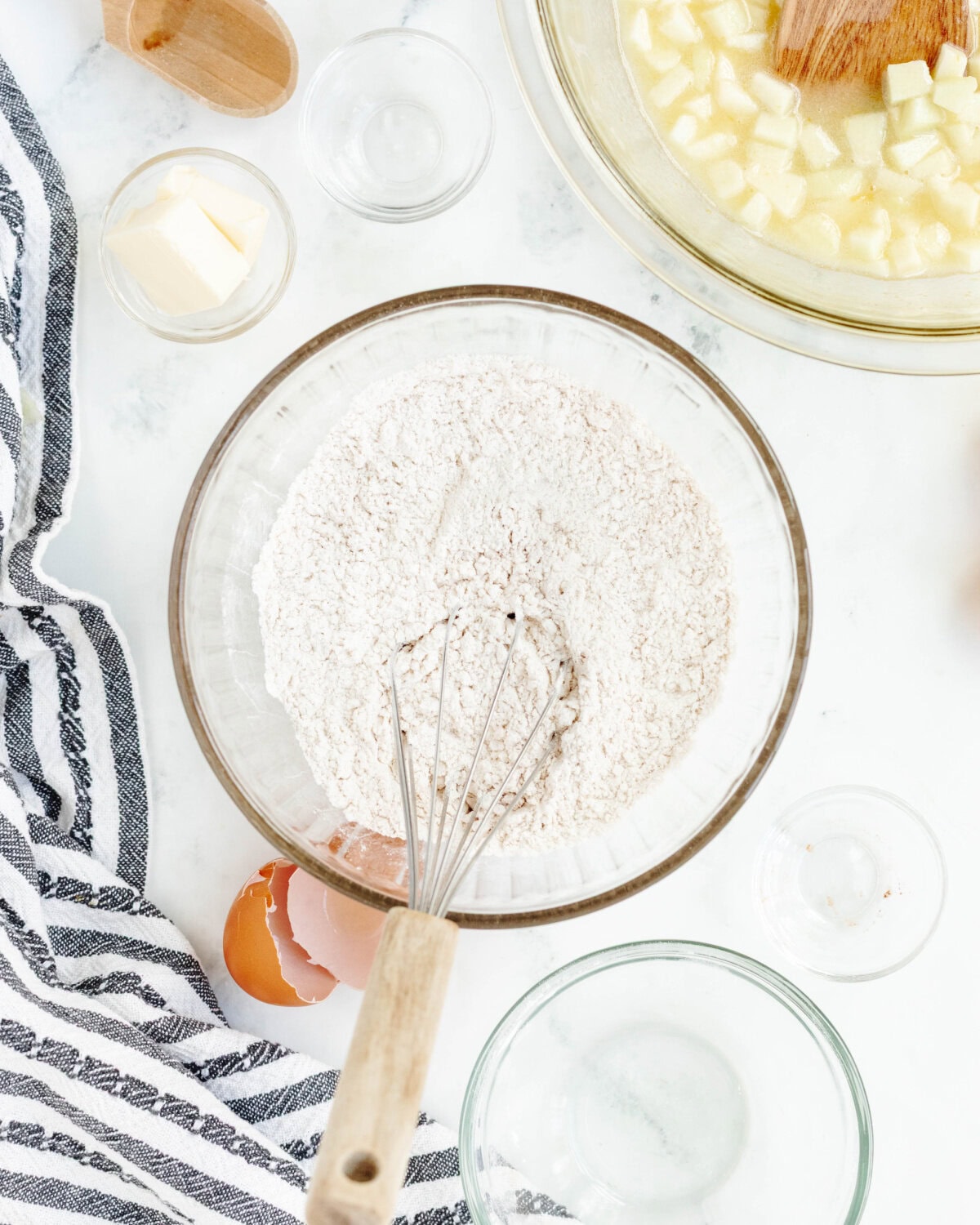 Flour, baking powder, salt, and cinnamon combined in a glass mixing bowl.