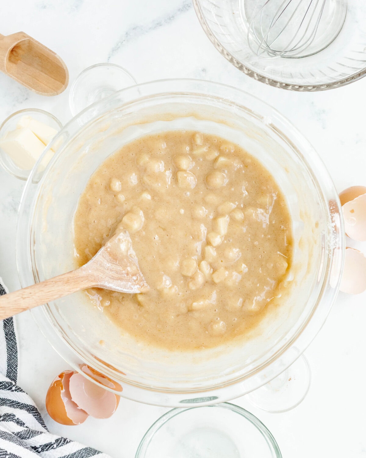 Dry ingredients combined with wet ingredients to form a batter in a glass mixing bowl.