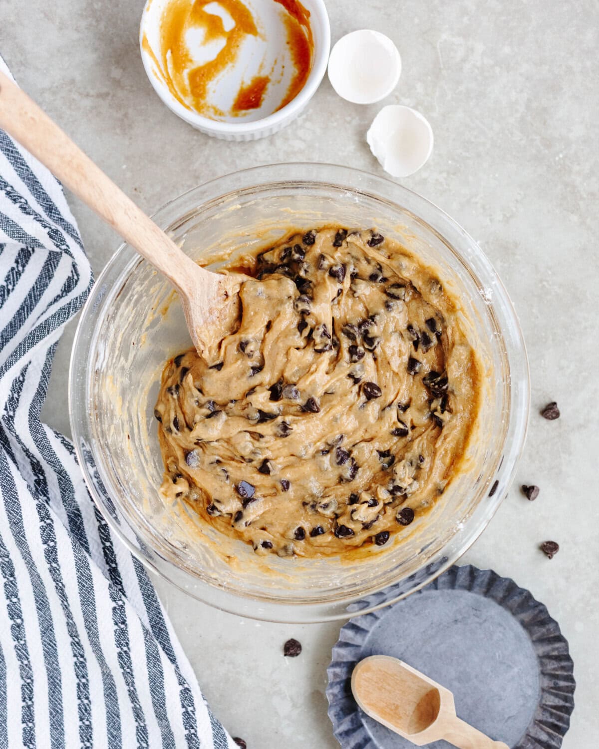 Chocolate chips folded into batter in a glass mixing bowl.