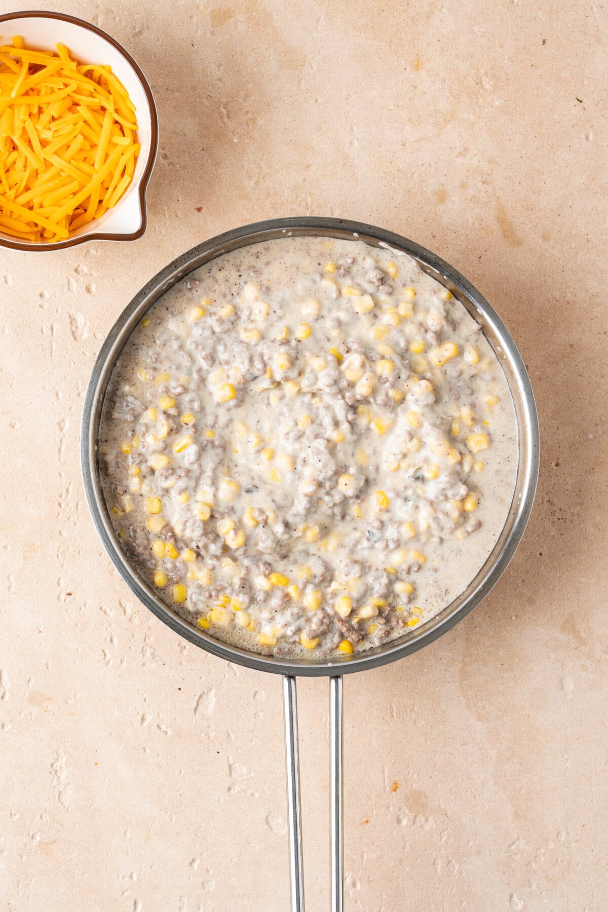Corn, sour cream, cream of mushroom, milk, and ground beef stirred together until creamy.