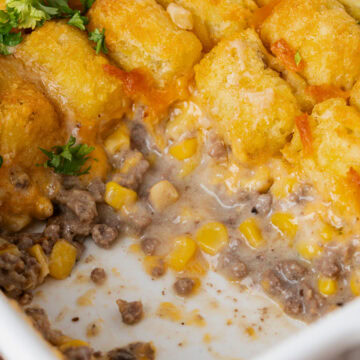 Creamy tater tot casserole in a white baking dish ready to serve.